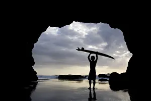 Surfer Inside A Cave At Muriwai North Island New Zealand Surfer Inside A Cave At Muriwai North Island New Zealand