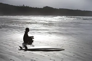 Surfer Meditating On Beach, Cox Bay Near Tofino, British Columbia, Canada Surfer Meditating On Beach, Cox Bay Near Tofino, British Columbia, Canada