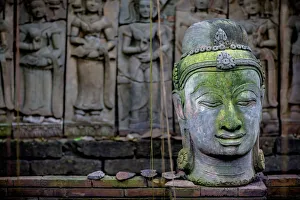 A Terra Cotta Head Of Buddha Sits In Front Of Bas-Relief In A Terra Cotta Garden A Terra Cotta Head Of Buddha Sits In Front Of Bas-Relief In A Terra Cotta Garden