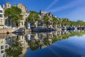 Typical houses refelected on the Herengracht Canal in Grachtengordel in the city center of Amsterdam, Holland Typical houses refelected on the Herengracht Canal in Grachtengordel in the city center of Amsterdam, Holland