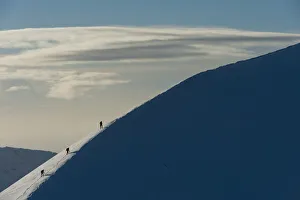 UK, Scotland, Walkers climbing snowy ridge of Sgorr Dhearg in winter near Glen Coe UK, Scotland, Walkers climbing snowy ridge of Sgorr Dhearg in winter near Glen Coe