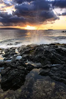 Water Splashing Onto The Lava Rock Along The Coast At Sunset; Hawaii, United States Water Splashing Onto The Lava Rock Along The Coast At Sunset; Hawaii, United States