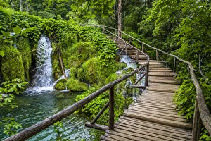Wooden footbridge crossing over the waterfalls at the Plitvice Lakes National Park, Croatia Wooden footbridge crossing over the waterfalls at the Plitvice Lakes National Park, Croatia