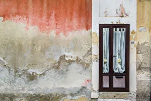 Worn, stone walls of a building with curtained door in Ragusa in Sicily, Italy Worn, stone walls of a building with curtained door in Ragusa in Sicily, Italy