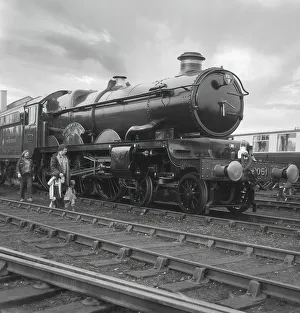 A young family walking along the tracks beside the Drysllwyn Castle steam engine 4-6-0; England A young family walking along the tracks beside the Drysllwyn Castle steam engine 4-6-0; England
