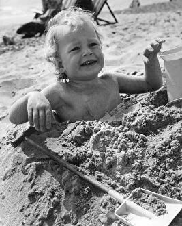 Images Dated 21st April 1971: 3 year old Bradley Hook up to his arm-pits in the sand at Bournemouth. April 1971 P023604