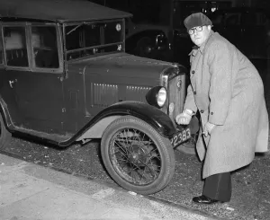 Actor Peter Sellers seen here trying to start his Austin 7 motor car outside the Paris Actor Peter Sellers seen here trying to start his Austin 7 motor car outside the Paris