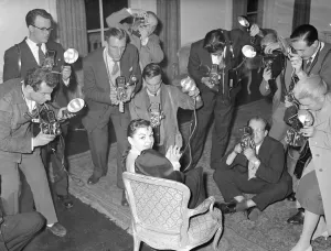 Actress Judy Garland at a press conference surronded by photographers taking Actress Judy Garland at a press conference surronded by photographers taking