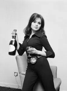 Actress Madeline Smith holding a glass of wine and bottle of champagne at a BBC Press Actress Madeline Smith holding a glass of wine and bottle of champagne at a BBC Press