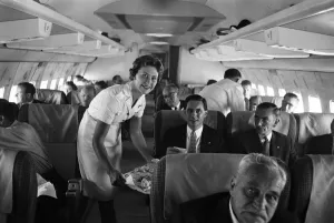 An air stewardess serving food to passengers on board a Qantas Boeing 707 plane at London An air stewardess serving food to passengers on board a Qantas Boeing 707 plane at London
