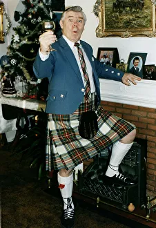 Andy Stewart singer holding goblet at home fireplace foot on fire christmass tree tartan Andy Stewart singer holding goblet at home fireplace foot on fire christmass tree tartan