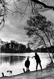 Angling. A young boy fishing with his father at Coombe Abbey pool Angling. A young boy fishing with his father at Coombe Abbey pool
