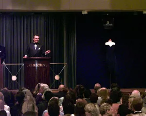 Auctioneer Lord Hindlip taking bids on Princess Dianas dcocktail dress in black silk Auctioneer Lord Hindlip taking bids on Princess Dianas dcocktail dress in black silk