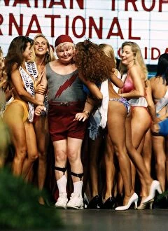 Images Dated 21st March 1991: Benny Hill Comedian stands between bikini clad contestrants at a beauty competition