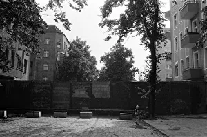 The Berlin Wall. The wall running into houses on either side of the road The Berlin Wall. The wall running into houses on either side of the road