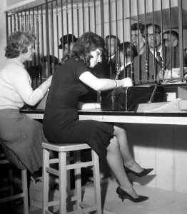 Bookies clerks taking bets from punters at a busy betting shop in Soho Bookies clerks taking bets from punters at a busy betting shop in Soho