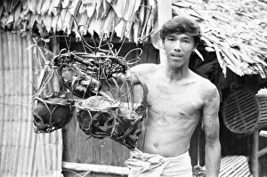 Images Dated 1st September 1975: A Borneo headhunter tribesman seen here holding up a basket of human skulls