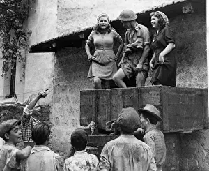 A British soldier helping the local villagers with the winepress after the Allied army A British soldier helping the local villagers with the winepress after the Allied army