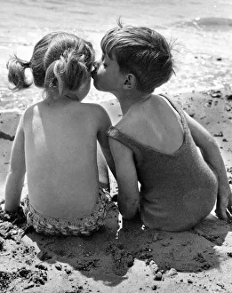 A brotherly kiss on the cheek for his sister while the two children enjoy their summer A brotherly kiss on the cheek for his sister while the two children enjoy their summer