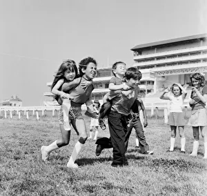 Children carrying their partners on their backs during a horse and jockey style egg Children carrying their partners on their backs during a horse and jockey style egg