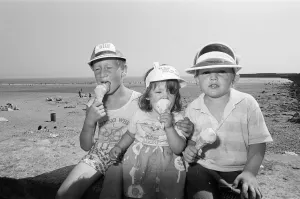 Children enjoy an ice cream as they try to keep cool on Coney Beach in Porthcawl Children enjoy an ice cream as they try to keep cool on Coney Beach in Porthcawl