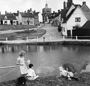 Children fishing for tadpoles and minnows in the village pond at Finchingfield Essex Children fishing for tadpoles and minnows in the village pond at Finchingfield Essex