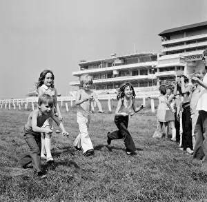 Children race across the finish line of the egg and spoon race on the Downs at Epsom Children race across the finish line of the egg and spoon race on the Downs at Epsom