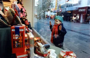 Christmas - A young child peers at the Christmas decorations Christmas - A young child peers at the Christmas decorations