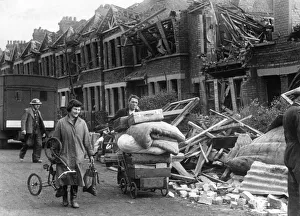 Couple carrying the remaining possessions from their bombed home in a pram following an Couple carrying the remaining possessions from their bombed home in a pram following an
