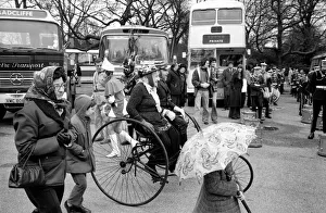 A couple ride their victorian tandam tricycle in the Easter parade, Battersea Park A couple ride their victorian tandam tricycle in the Easter parade, Battersea Park
