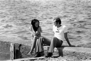 Couple sitting on a wall by he sea in Limassol, Cyprus May 1975 Couple sitting on a wall by he sea in Limassol, Cyprus May 1975