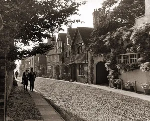 Couple walking down a quiet cobbled road in Rye Sussex Couple walking down a quiet cobbled road in Rye Sussex