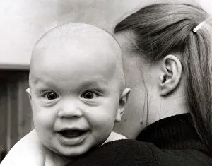 A cute baby looking over shoulder of his mother February 1979 A cute baby looking over shoulder of his mother February 1979