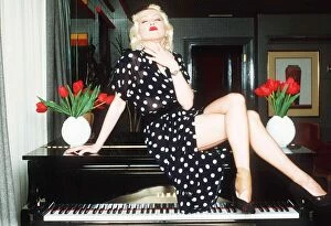 Images Dated 15th May 1989: Cyndi Lauper Singer Actress sitting in top of grand piano in black