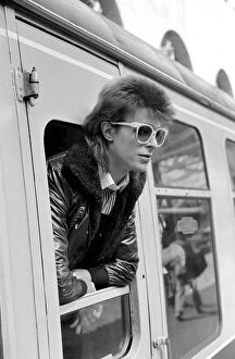 Images Dated 9th July 1973: David Bowie leaning out of a railway carriage of the Paris boat train at Victoria station