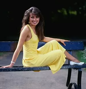 Images Dated 1st July 1987: Debbie Greenwood TV presenter July 1987 sitting o a bench wearing a yellow dress