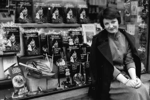 Delia Smith TV Chef and writer sits outside bookshop that has a window full of her books Delia Smith TV Chef and writer sits outside bookshop that has a window full of her books