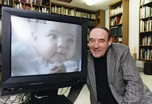 Images Dated 10th February 1993: Desmond Morris anthropologist tv presenter baby watching at his home in Oxford