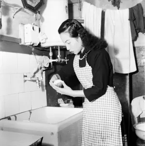 Domestic Scenes A woman peeling potatoes in her kitchen sink, getting dinner ready Domestic Scenes A woman peeling potatoes in her kitchen sink, getting dinner ready