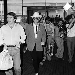 Images Dated 10th August 1980: Dressed in a stetson hat, Elton John leaves Heathrow Airport for America