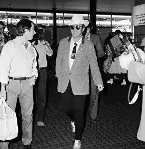 Images Dated 10th August 1980: Dressed in a stetson hat, Elton John leaves Heathrow Airport for America