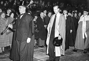 DUKE OF EDINBURGH, WEARING GOWN AND HOLDING HIS HAT, AT CAMBRIDGE UNIVERSITY WALKING IN DUKE OF EDINBURGH, WEARING GOWN AND HOLDING HIS HAT, AT CAMBRIDGE UNIVERSITY WALKING IN