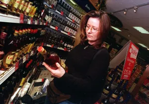 Duty free shop at Edinburgh airport February 1999 Woman looking at bottle of spirits Duty free shop at Edinburgh airport February 1999 Woman looking at bottle of spirits