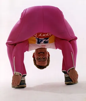 Eddie Edwards in pink ski clothing bending down and touching his heels Eddie Edwards in pink ski clothing bending down and touching his heels
