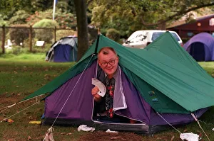 Edinburgh Festival August 1999 Man poking head out of tent holding palying cards Edinburgh Festival August 1999 Man poking head out of tent holding palying cards