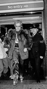 Elton John arrives at Heathrow Airport, and has to run from the crowds of fans who are Elton John arrives at Heathrow Airport, and has to run from the crowds of fans who are