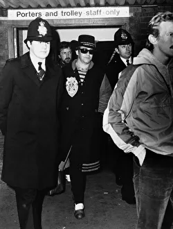 Elton John, pictured at Heathrow Airport, surrounded by police after getting off Elton John, pictured at Heathrow Airport, surrounded by police after getting off