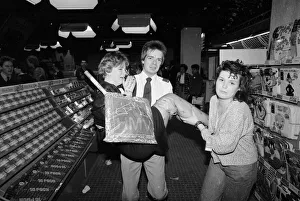 An emotional fan of the pop group Bros is carried away from a record store by a security An emotional fan of the pop group Bros is carried away from a record store by a security
