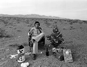 Images Dated 21st December 1970: Engelbert Humperdinck sitting in a chair with a Christmas tree