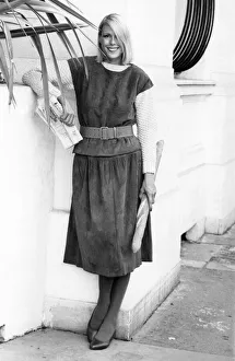 Fashion - Suits. Woman models a two piece suit, over the knee skirt Fashion - Suits. Woman models a two piece suit, over the knee skirt